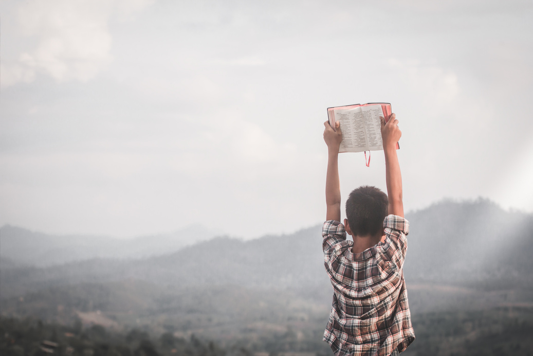 Boy Holding Bible Up 